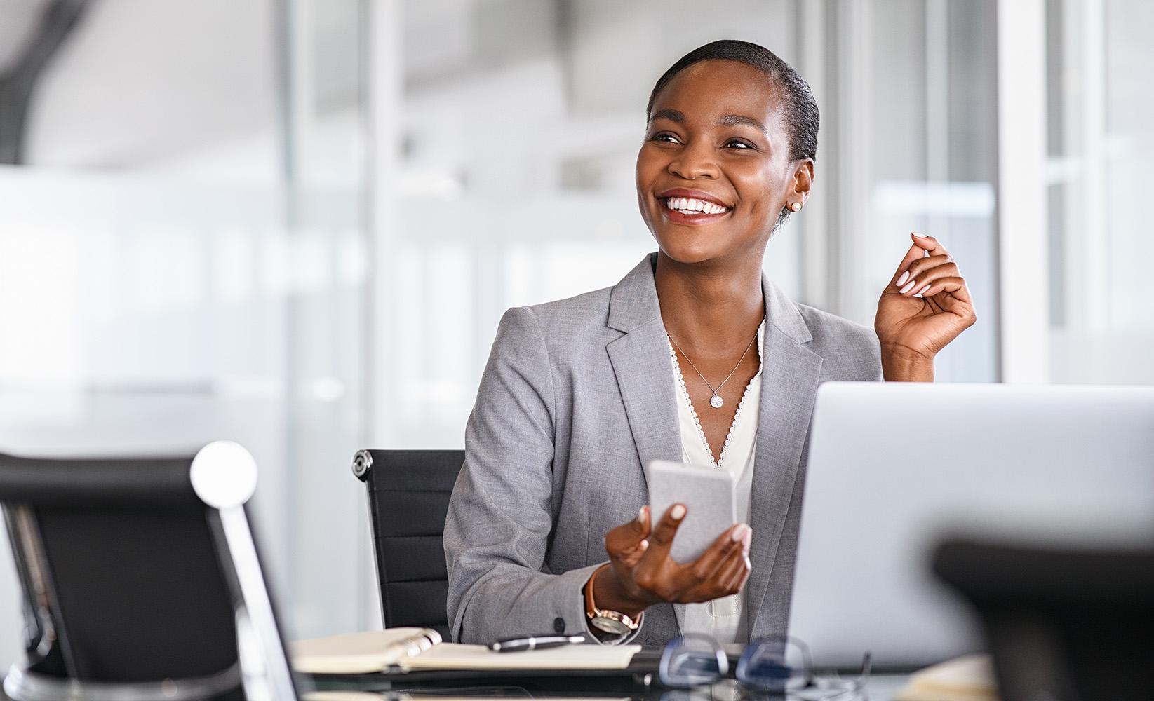A black female insurance agent smiles after getting an instant quote for her client.